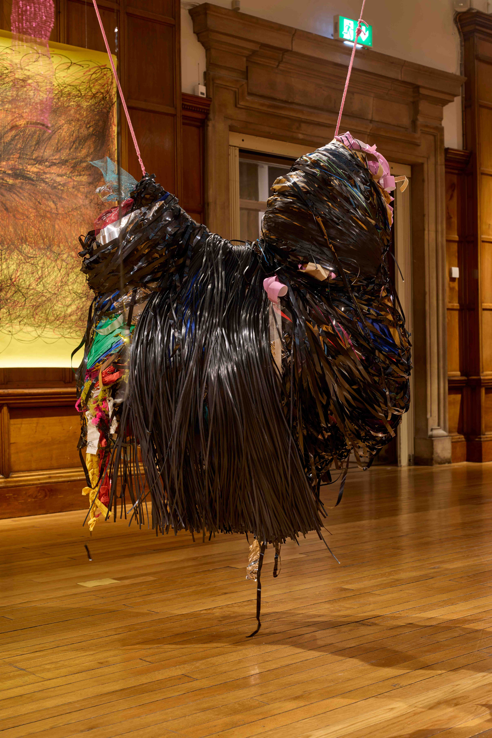 Black hanging sculpture made out of vhs tape and other materials