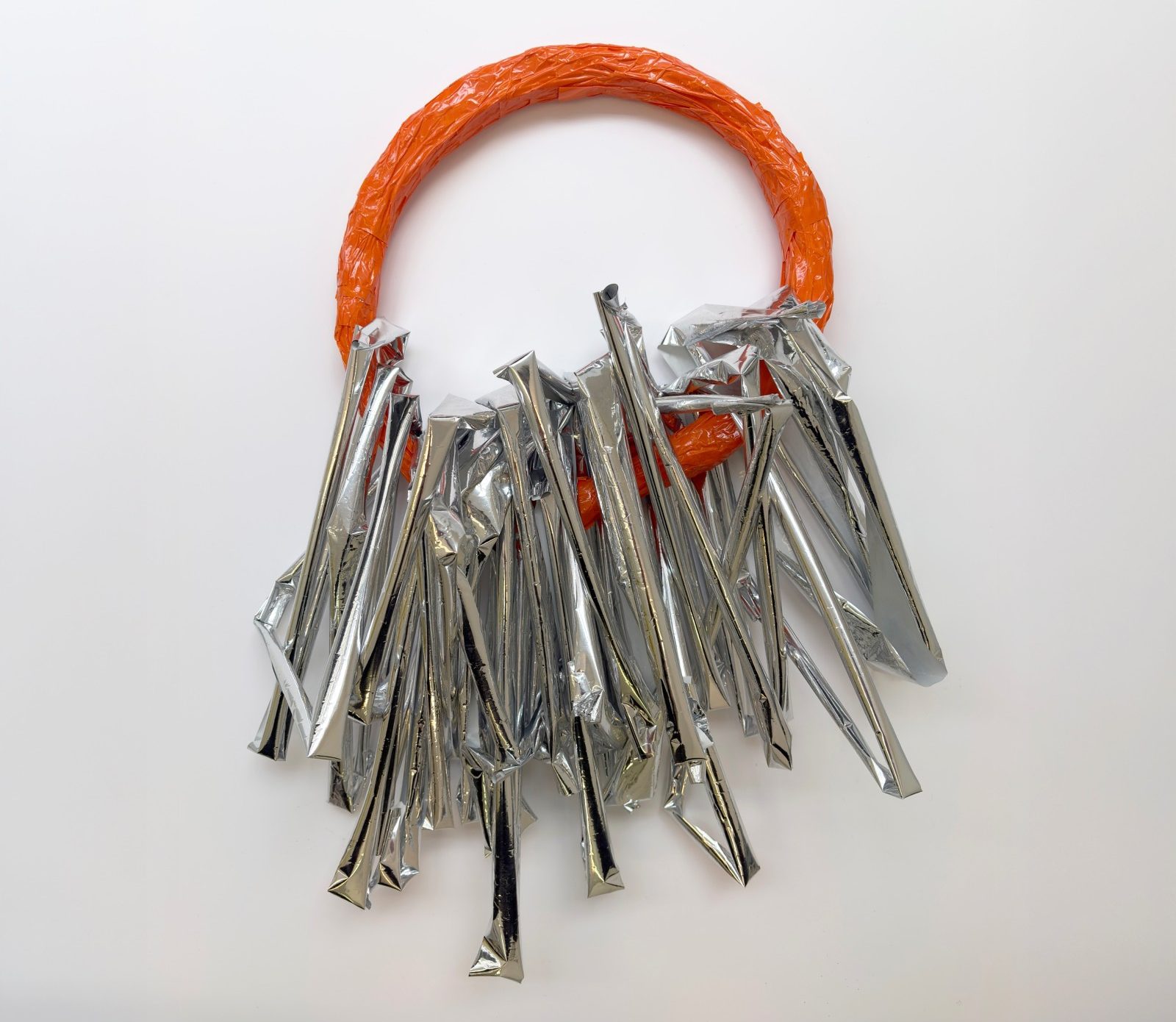 Linda Bell's artwork, showing a orange hoop with silver foil attached.