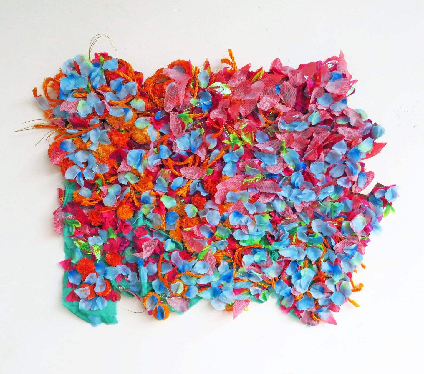 A vibrant textile artwork with layers of blue, red, pink and orange fabric arranged organically on top another.