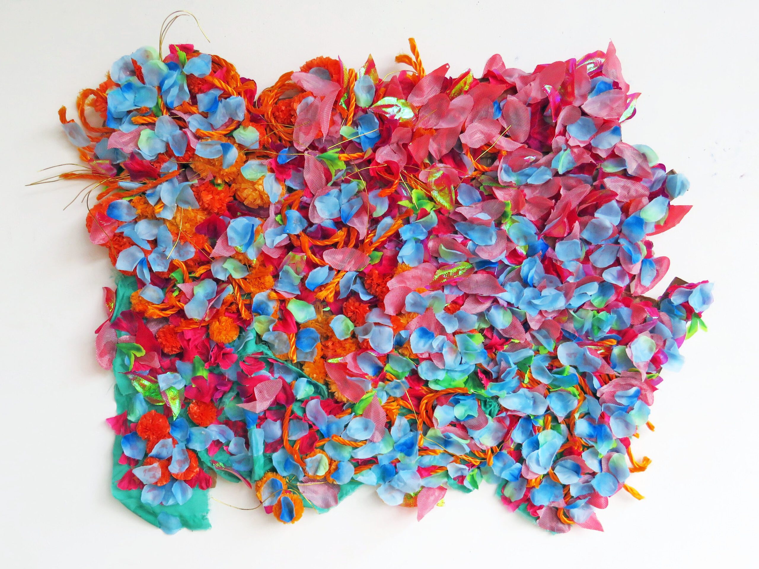 A vibrant textile artwork with layers of blue, red, pink and orange fabric arranged organically on top another.