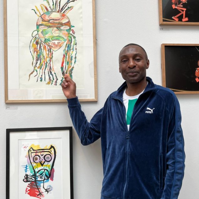 Artist Adam Crown standing in front of his artwork.