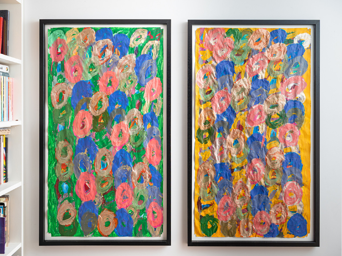 Two paintings by Kwaga Sillingi hanging on a white wall.