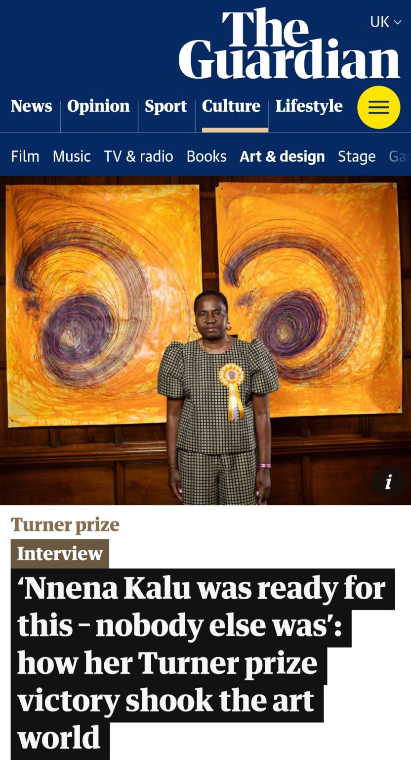 Nnena Kalu infront of artwork in The Guardian article.