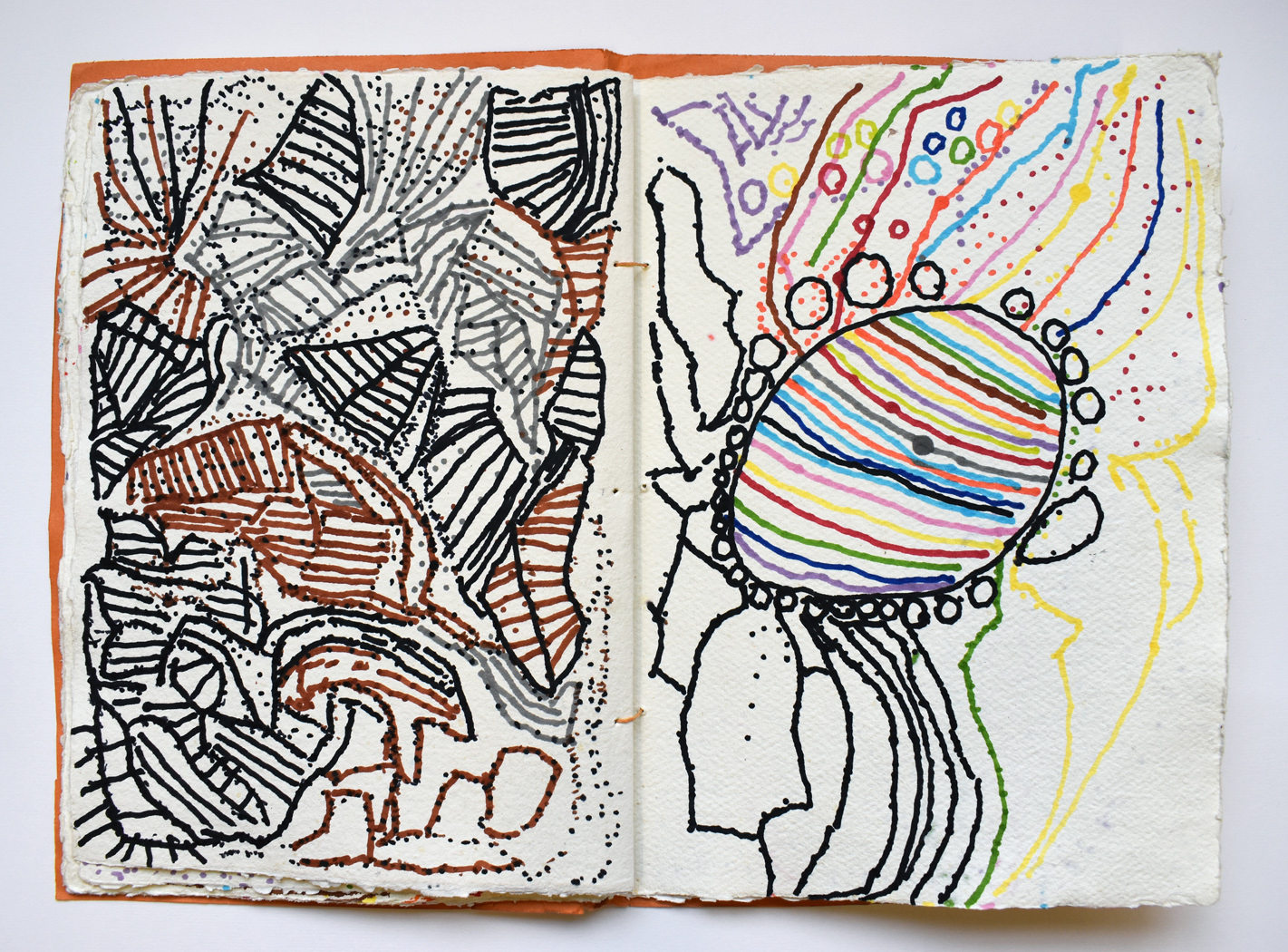 A sketchbook laying open. The pages are filled with colourful drawings in pen.