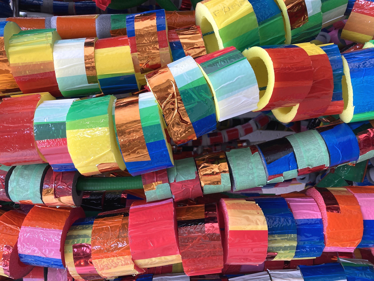 Detail on a sculptural artwork made up of foam loops covered in coloured tapes.