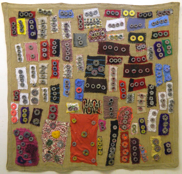 A large textile artwork with smaller squares sewn on top.