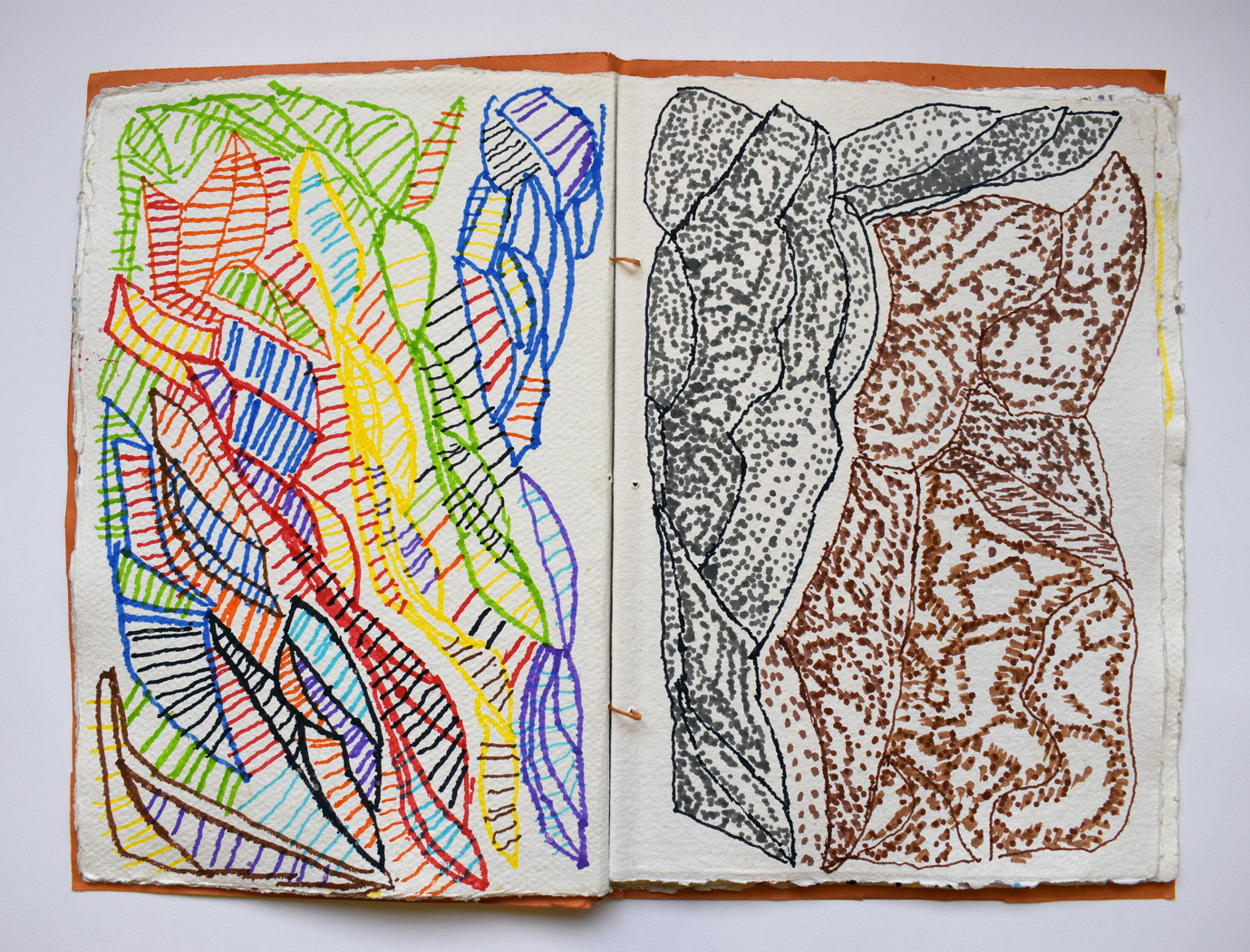 A sketchbook laying open. The pages are filled with colourful drawings in pen.