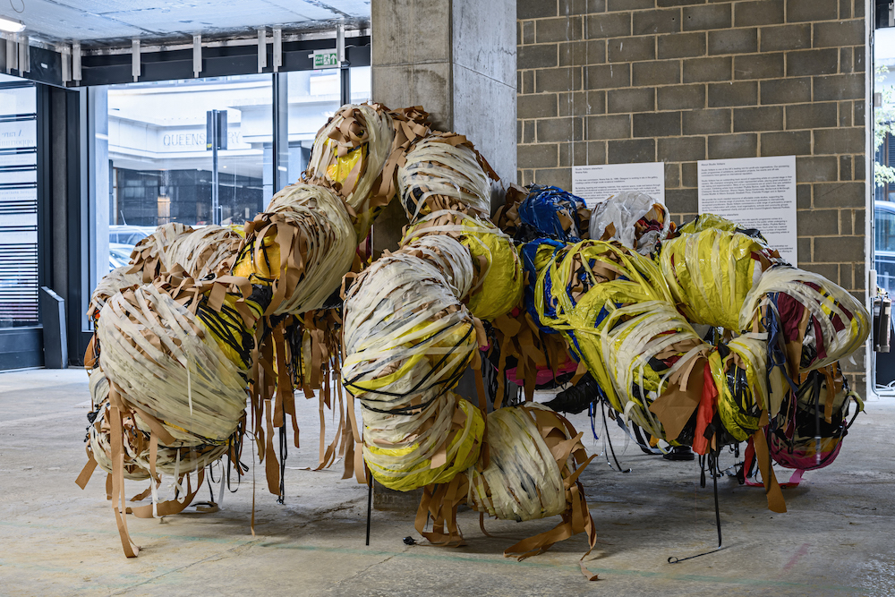 Nnena Kalu's artwork is shown in a gallery space. It is a large sculptural piece, consisting of bound together fabric.