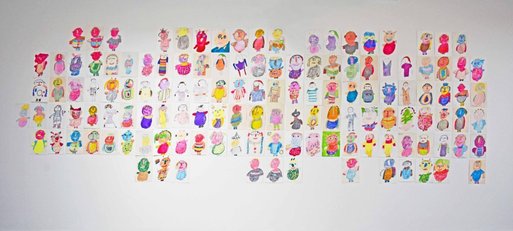 White wall covered in dozens of A4 colourful illustrations of portraits and characters.