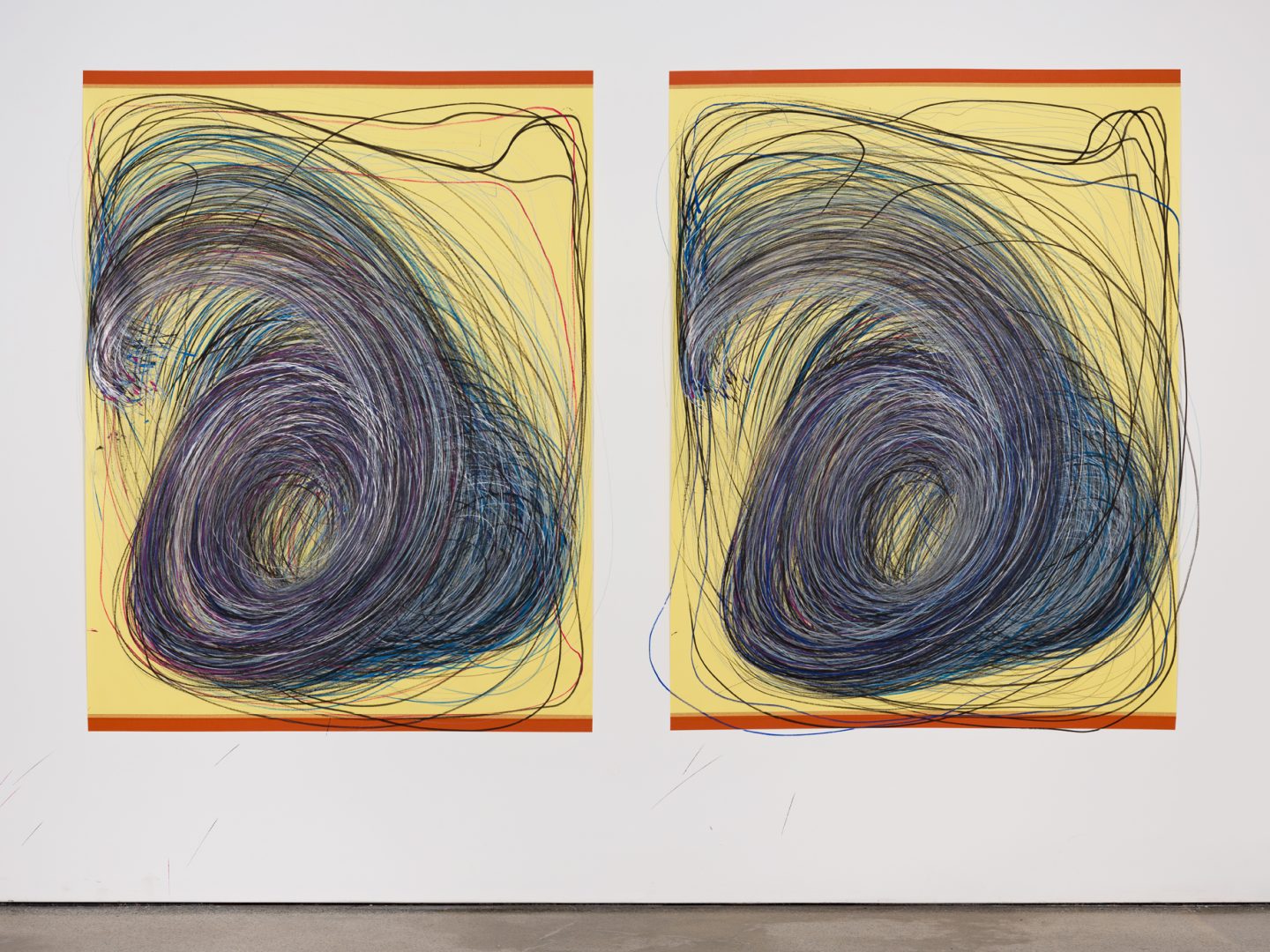 Photo of two large scale drawings by Nnena Kalu. The drawings are drawn in blue, black and purple mixed media on yellow paper. They are fixed to the wall with red tape at the top and bottom of the artworks.