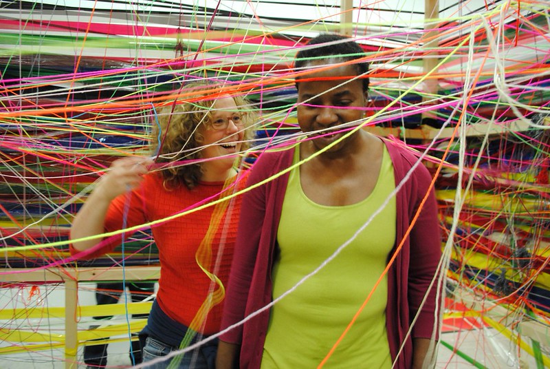 Artist Nnena Kalu stood inside an installation made of yarn with another woman.
