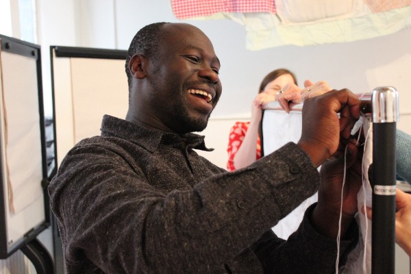 Andrew Omoding, smiling whilst working.