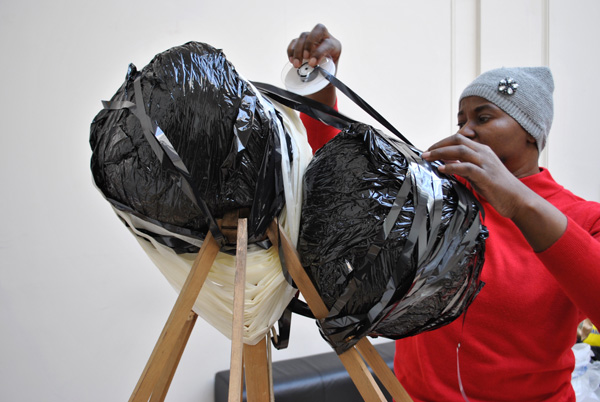 Artist Nnena Kalu installing her artwork for the exhibition.