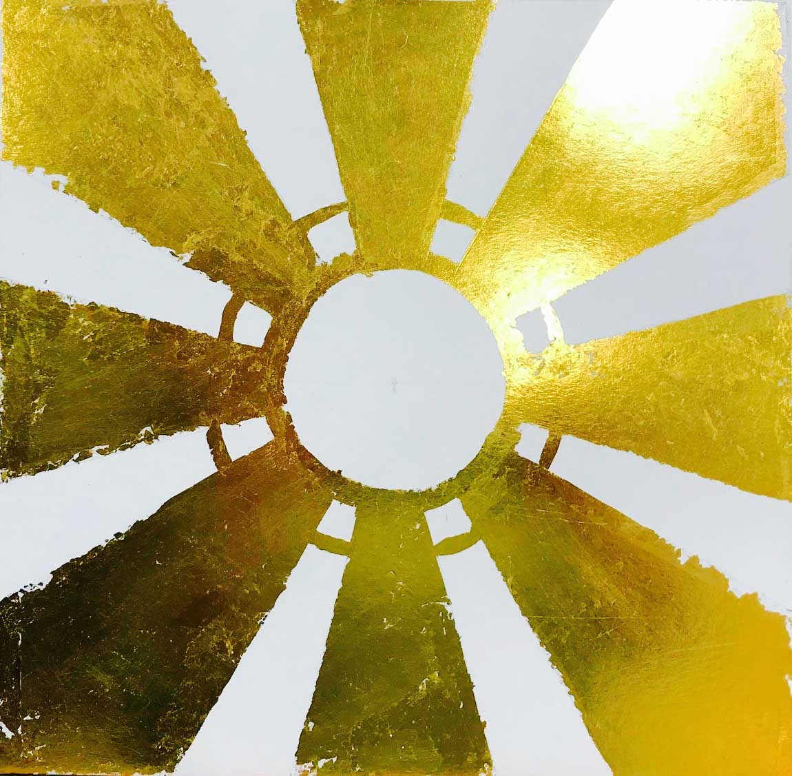 An artwork with gold leaf applied to rays extending from a centre with two concentric circles.