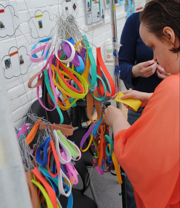 Linda Bell attaches colourful hoops to one of her sculptural works.