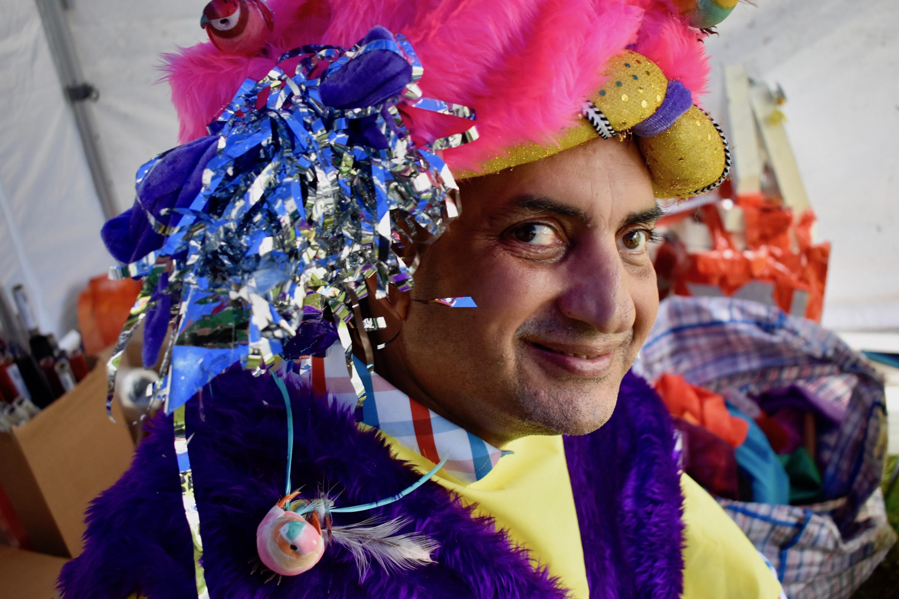 A close-up of artist Pardip Kapil wearing a custom bright pink boa turban with blue and silver tinsel.