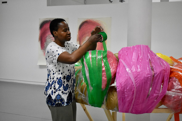 Nnena Kalu installing one of her artworks in the gallery space.