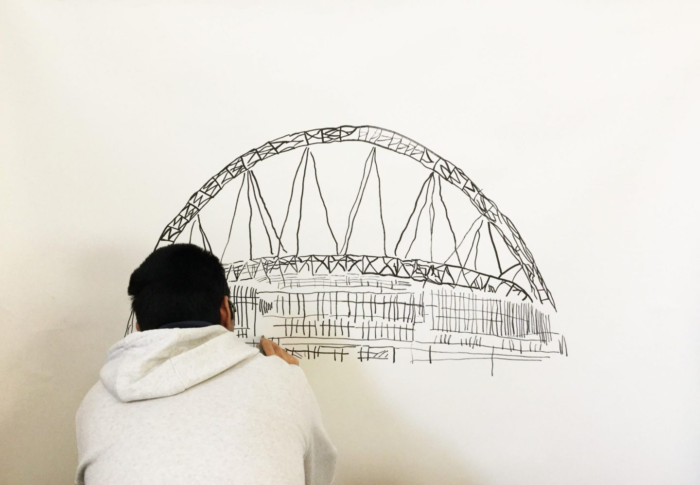 Abubakar Akram working on a drawing in pen.
