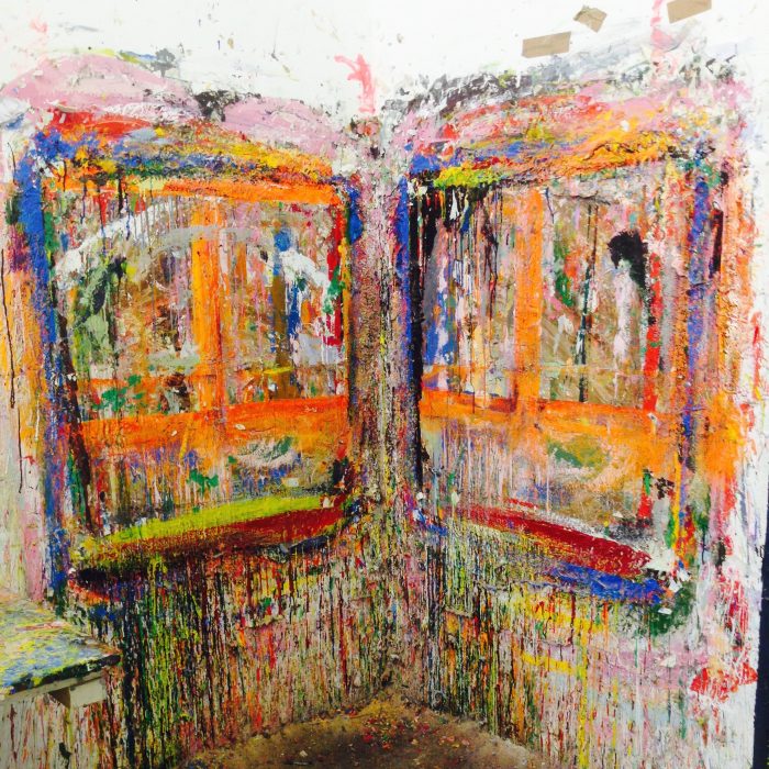 A wall in Nnena's old studio, showing layers of paint, with colourful streaks all over it.