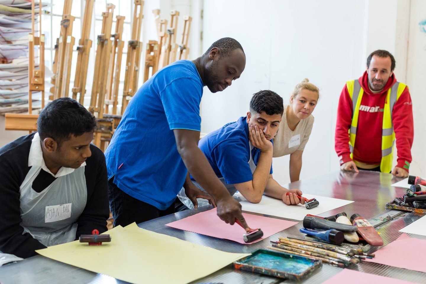 Artist Andrew Omoding demonstrating how to roll ink for printmaking.