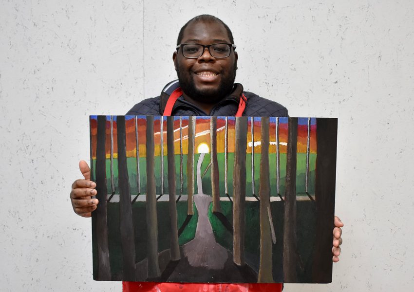 Immanuel Adelowo holding his artwork, Into The Depths (2024), acrylic paint on board, 64.5 x 44.5 cm, 2025. Image courtesy of the Artist and ActionSpace.
