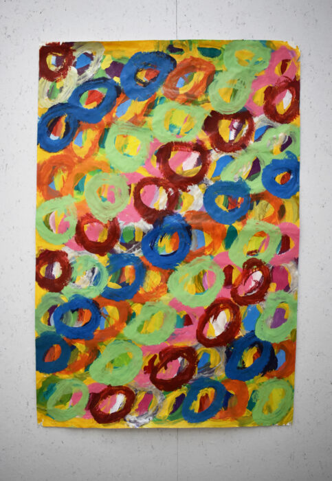 An abstract painting by Kwaga Sillingi. The painting is of layered multi coloured circles.