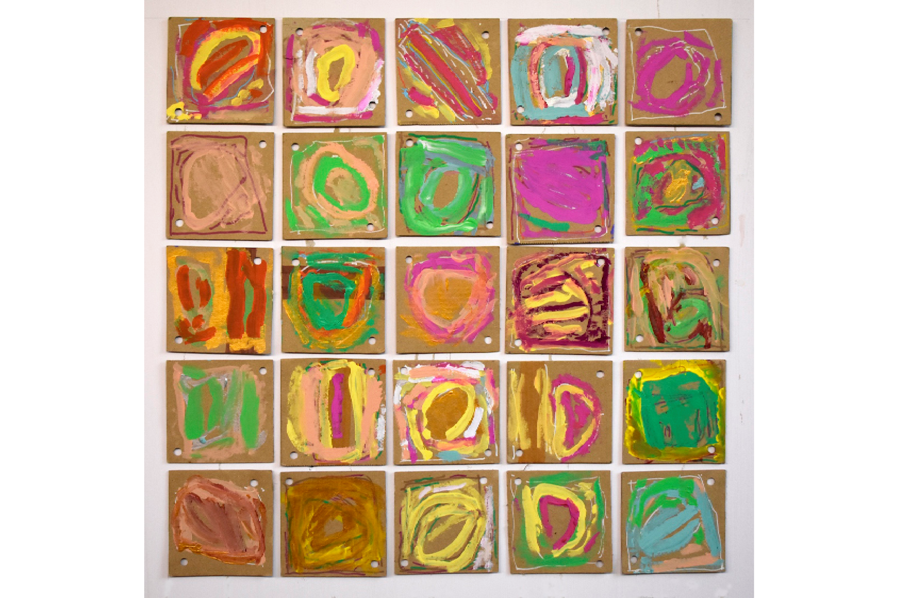 An artwork made on square cardboard tiles with antipodal holes in two corners, that has been laid out in a larger square formation. Bright coloured paint and white pen form gestural and organic cell-like whorl forms.