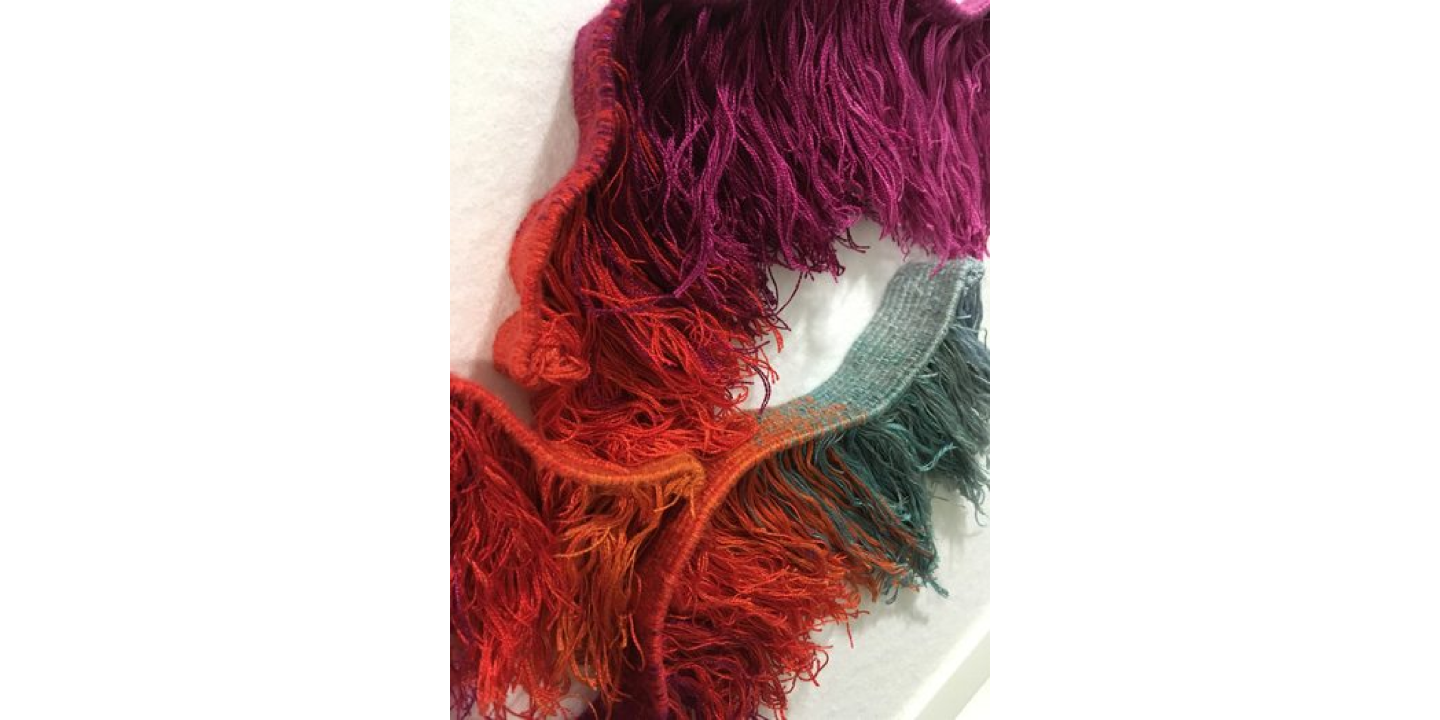 Close up of a woven textile tassel artwork.