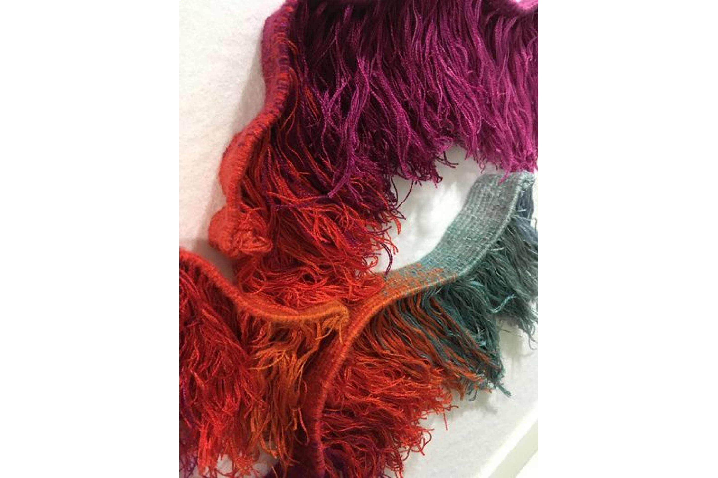 Close up of a woven textile tassel artwork.