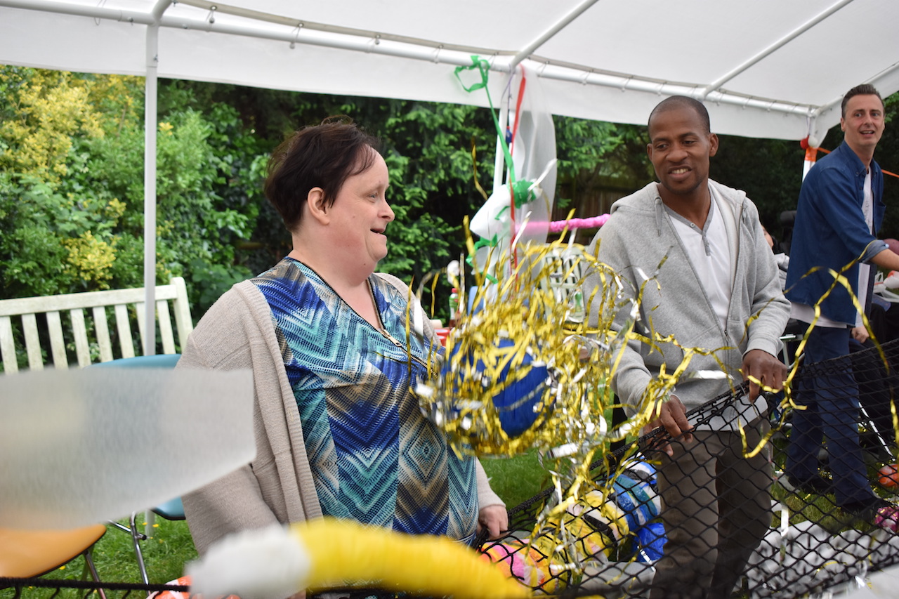 Artist Linda Bell and participants interacting with one of her netted sculptures.