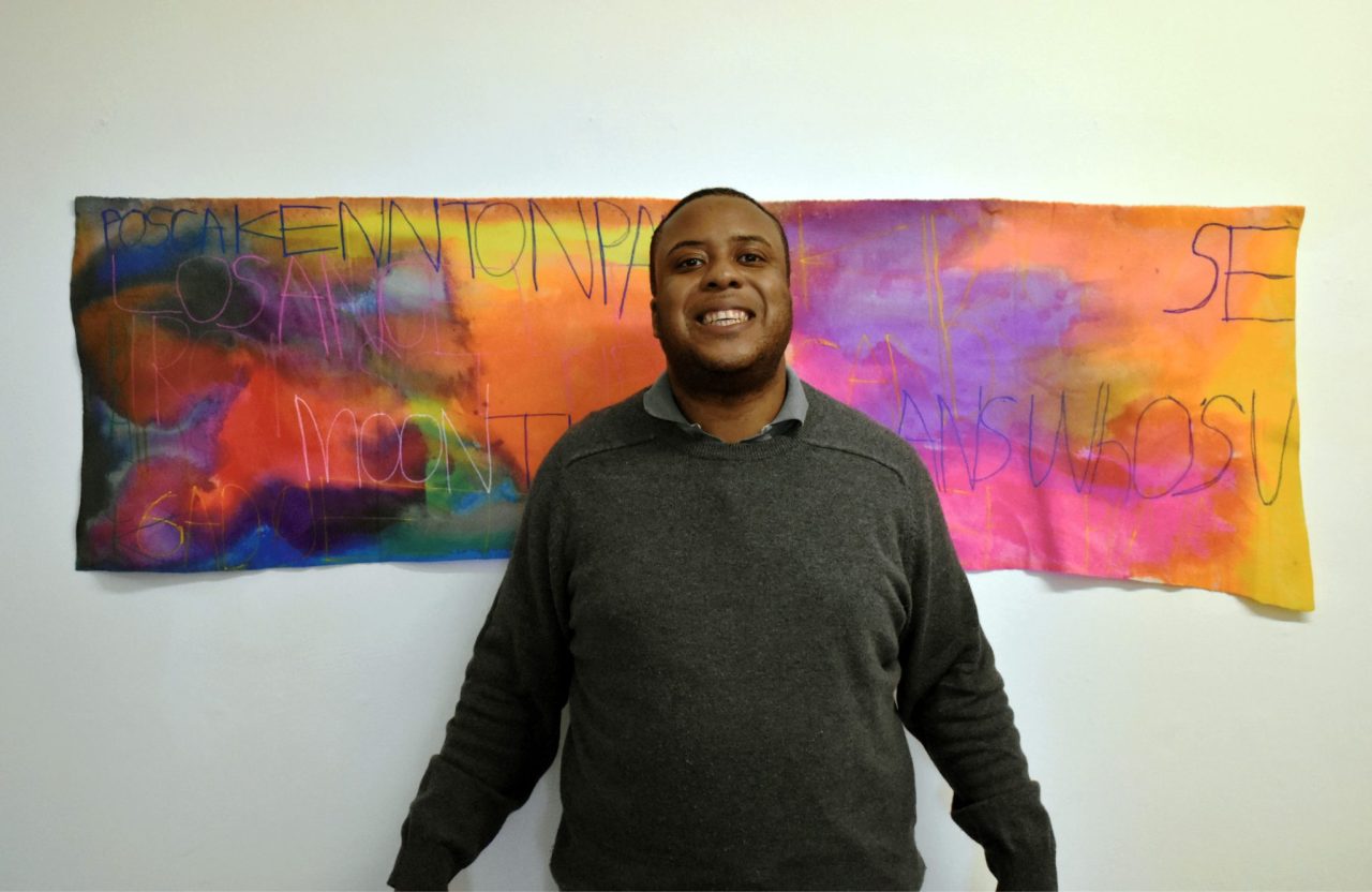 Patrick Moses standing in front of his work, Moon (2024).Image courtesy of the Artist and ActionSpace.