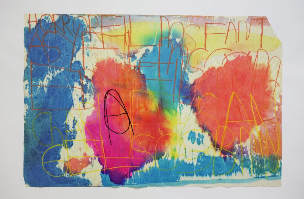 Multicoloured inks on paper with text written across in landscape.