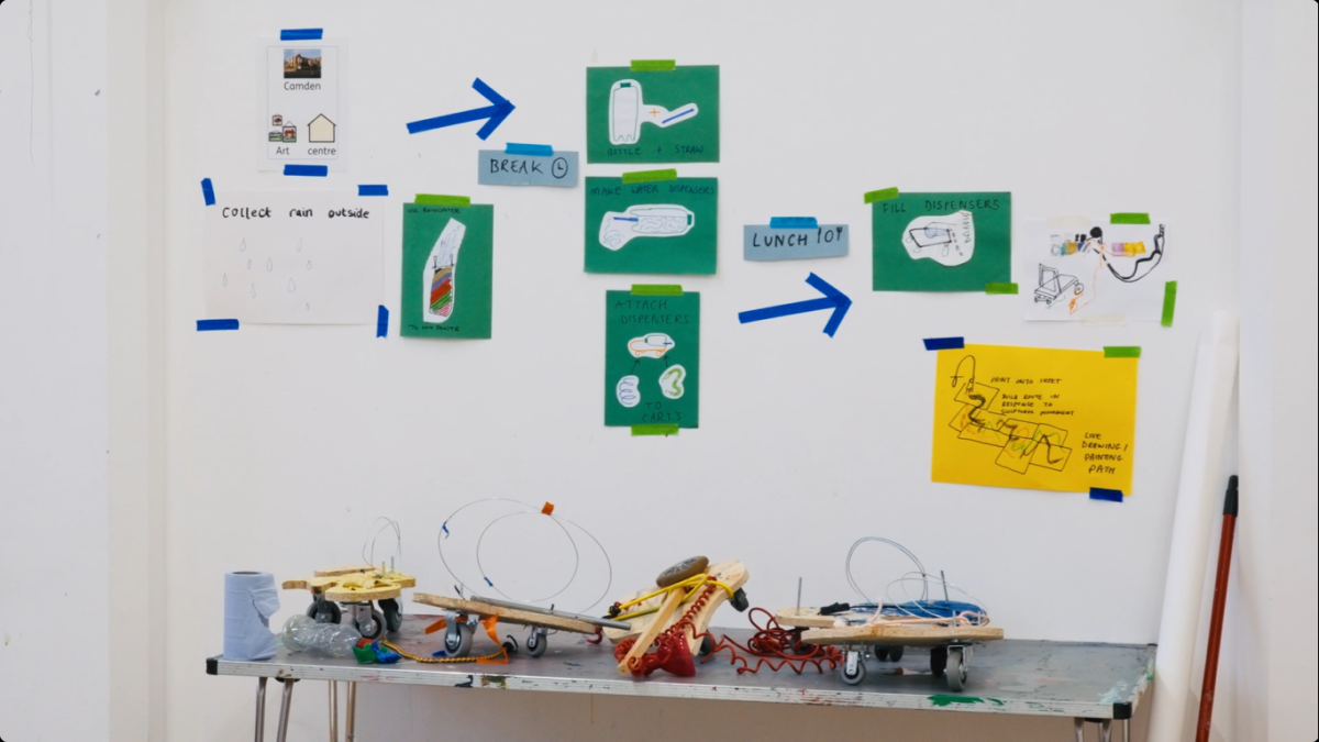 Declan Leslie's artwork at Camden Art Centre, showing green and white paper diagrams on the walls and miscellaneous objects on a table.
