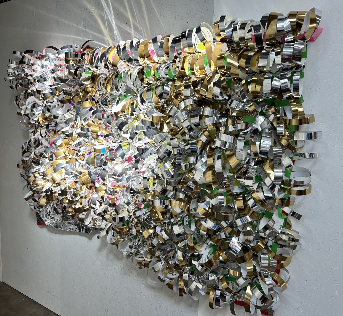 many rolls created from foil tape are mounted onto a black net