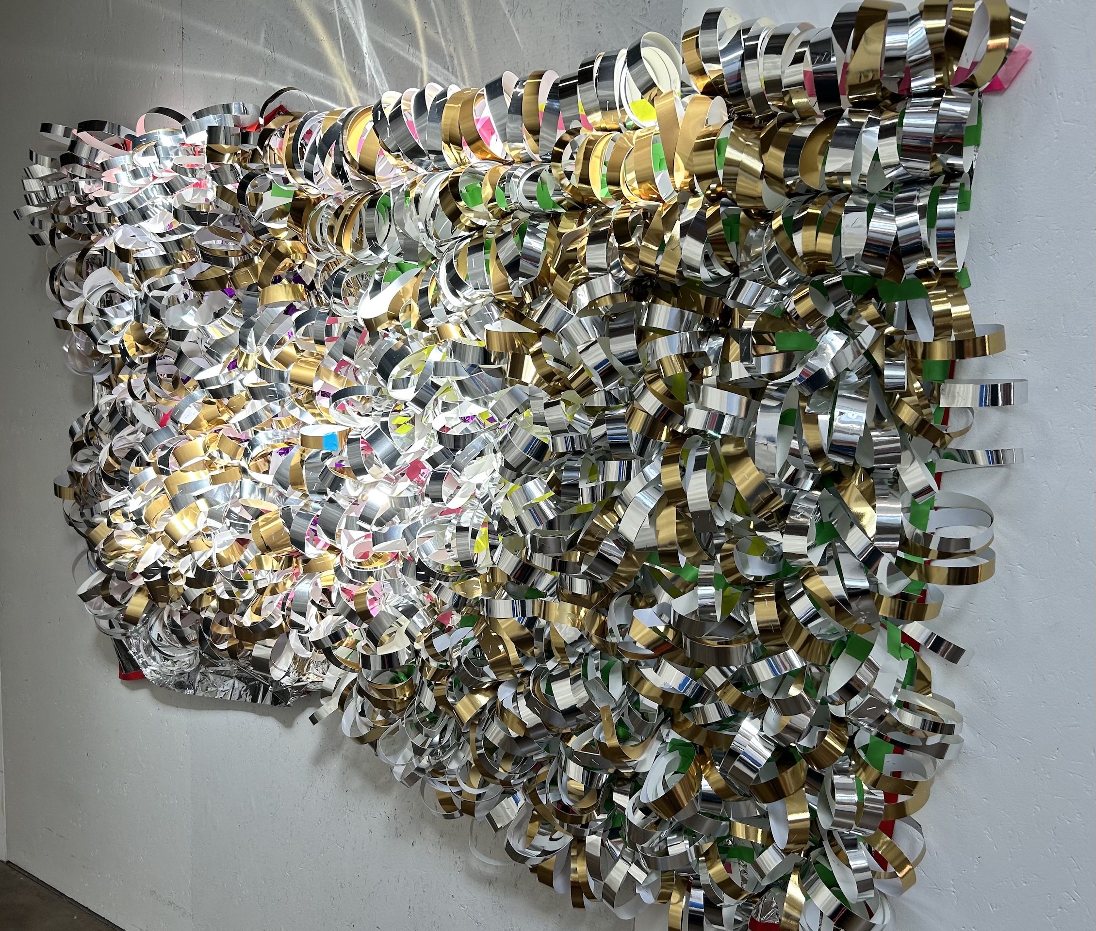many rolls created from foil tape are mounted onto a black net