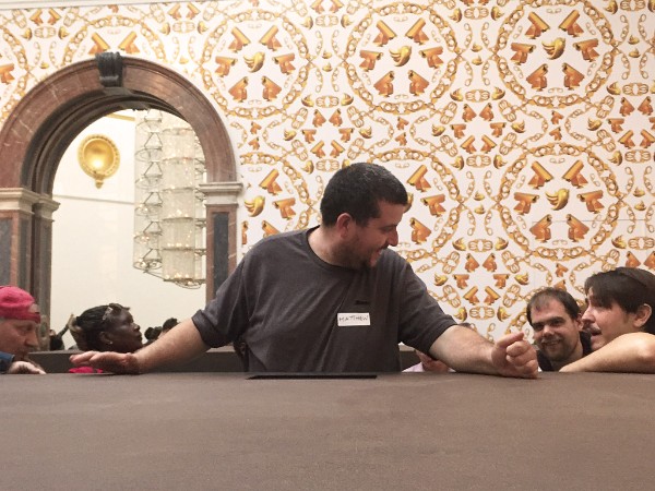 3 men smile at each other. They are in the RA building.