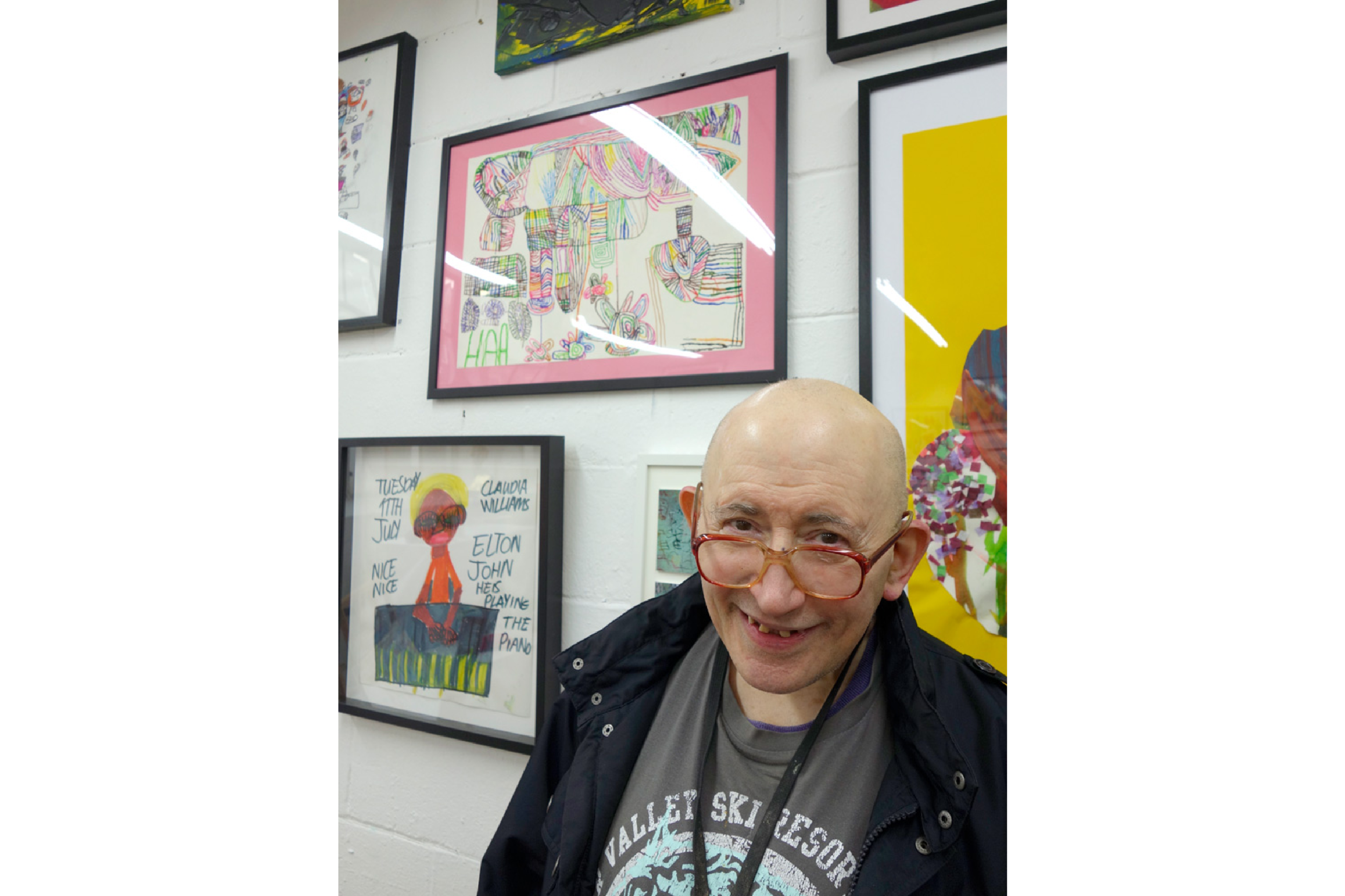 Hymie Aaronberg stood in front of a salon wall of art.