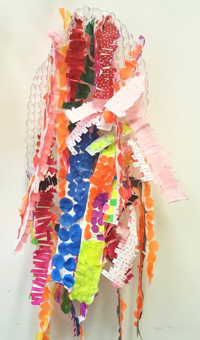 Helen Biney's artwork. Its a textural sculpture, made of small strips of colourful fabric glued together and displayed vertically.