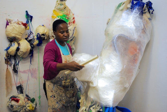 Artist Nnena Kalu working on a new sculpture, wrapping clingfilm around an armature.