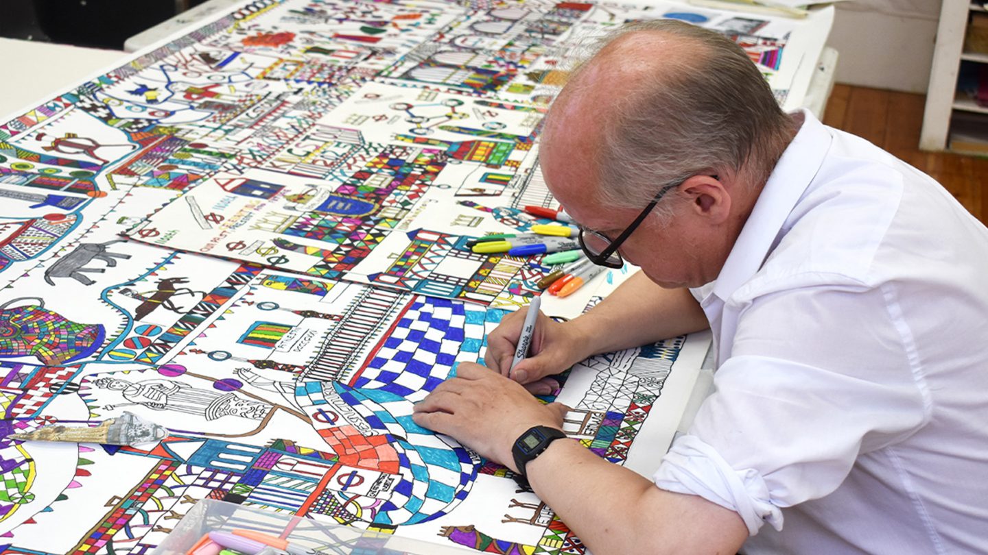 A man sat down drawing.