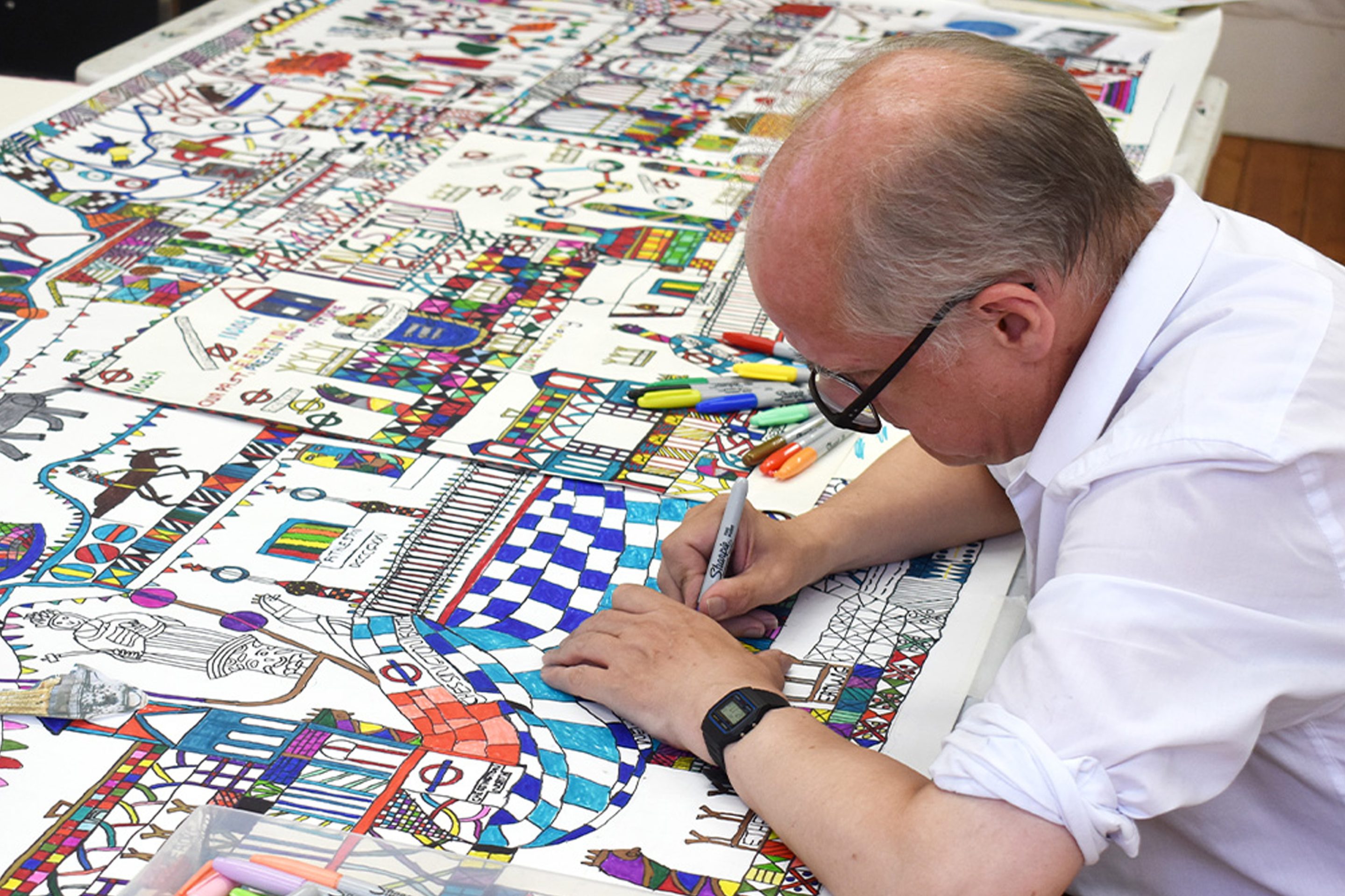 A man sat down drawing.