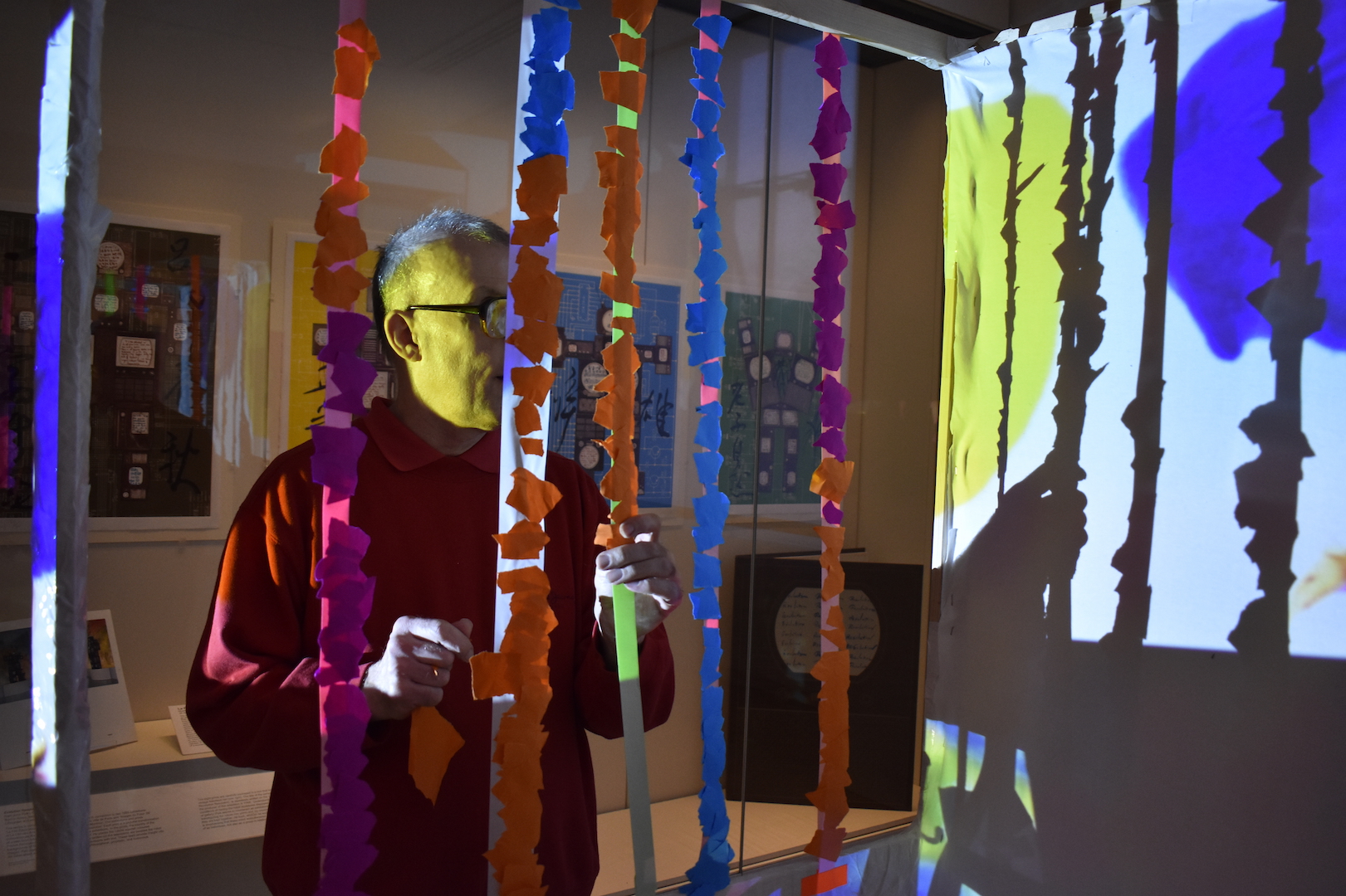 Artist Mark Lawrence adding paper and tape to an artwork as part of a live art event.