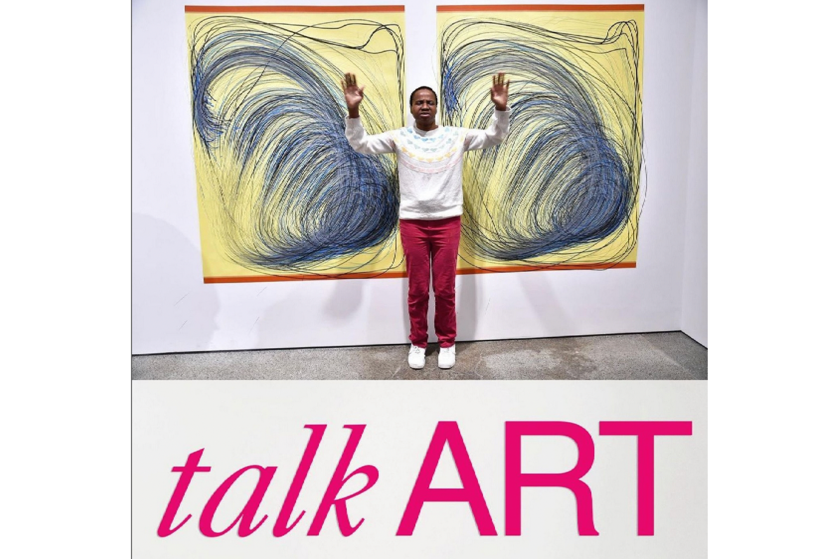 Nnena Kalu standing between two of her artworks displayed on a wall