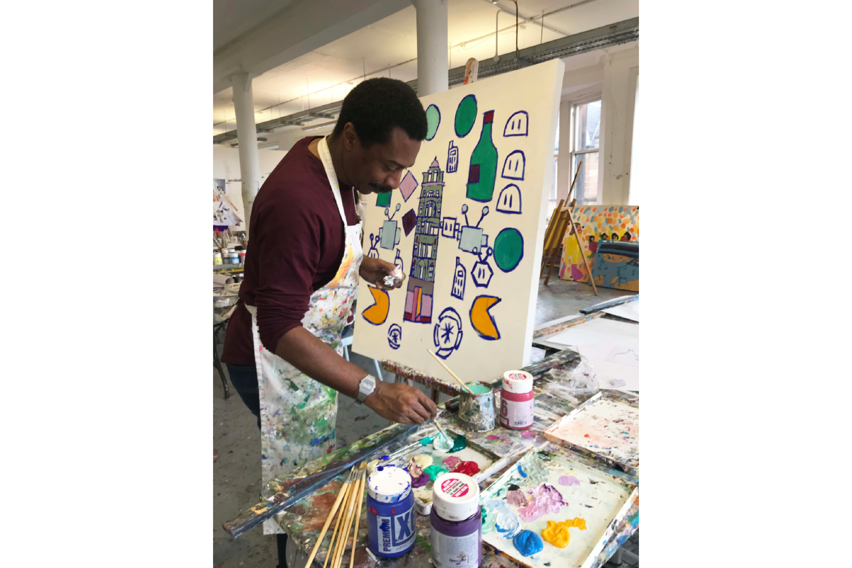 Artist Thompson Hall painting on an easel.