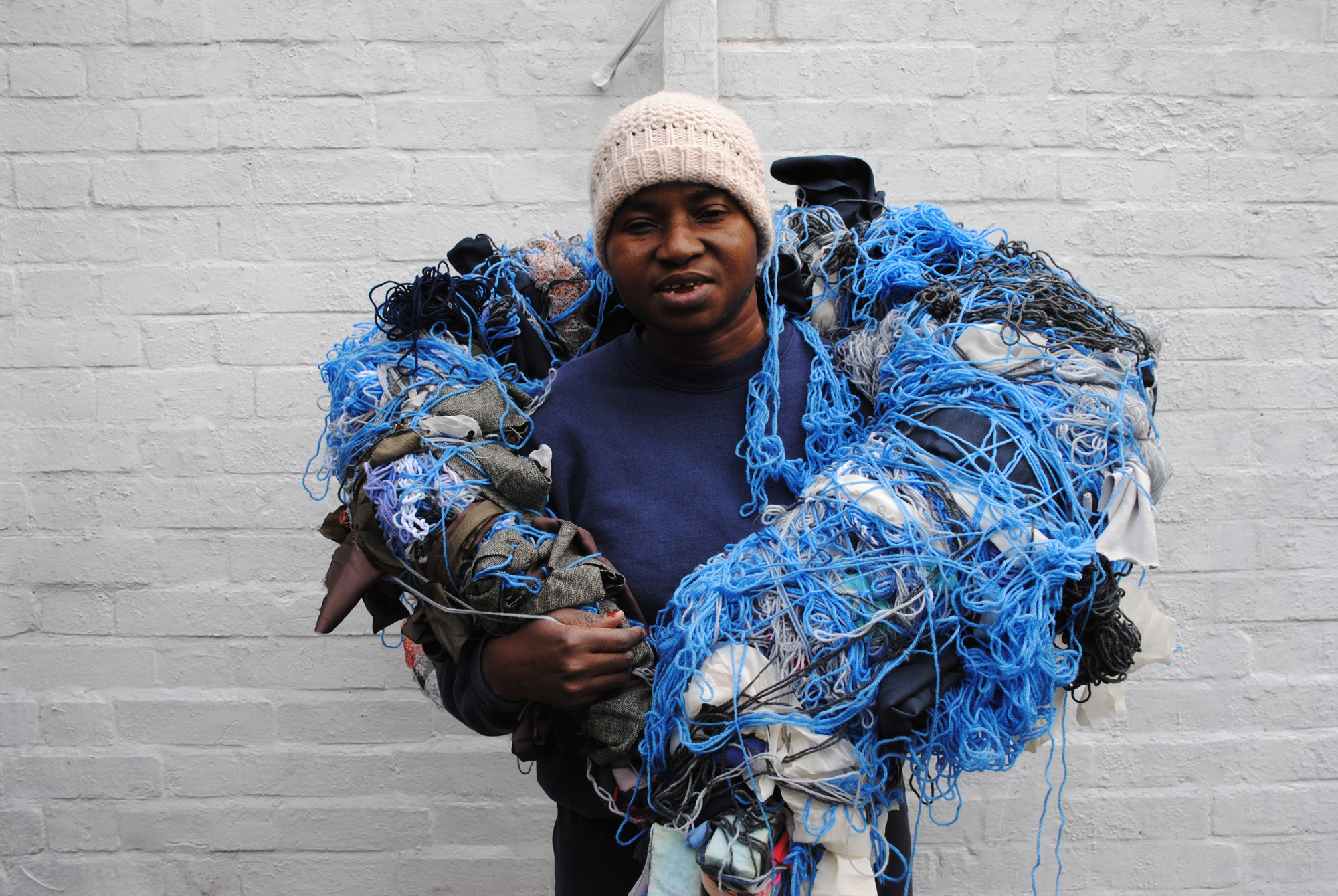 Artist Nnena Kalu holding one of her sculptures over her shoulders.