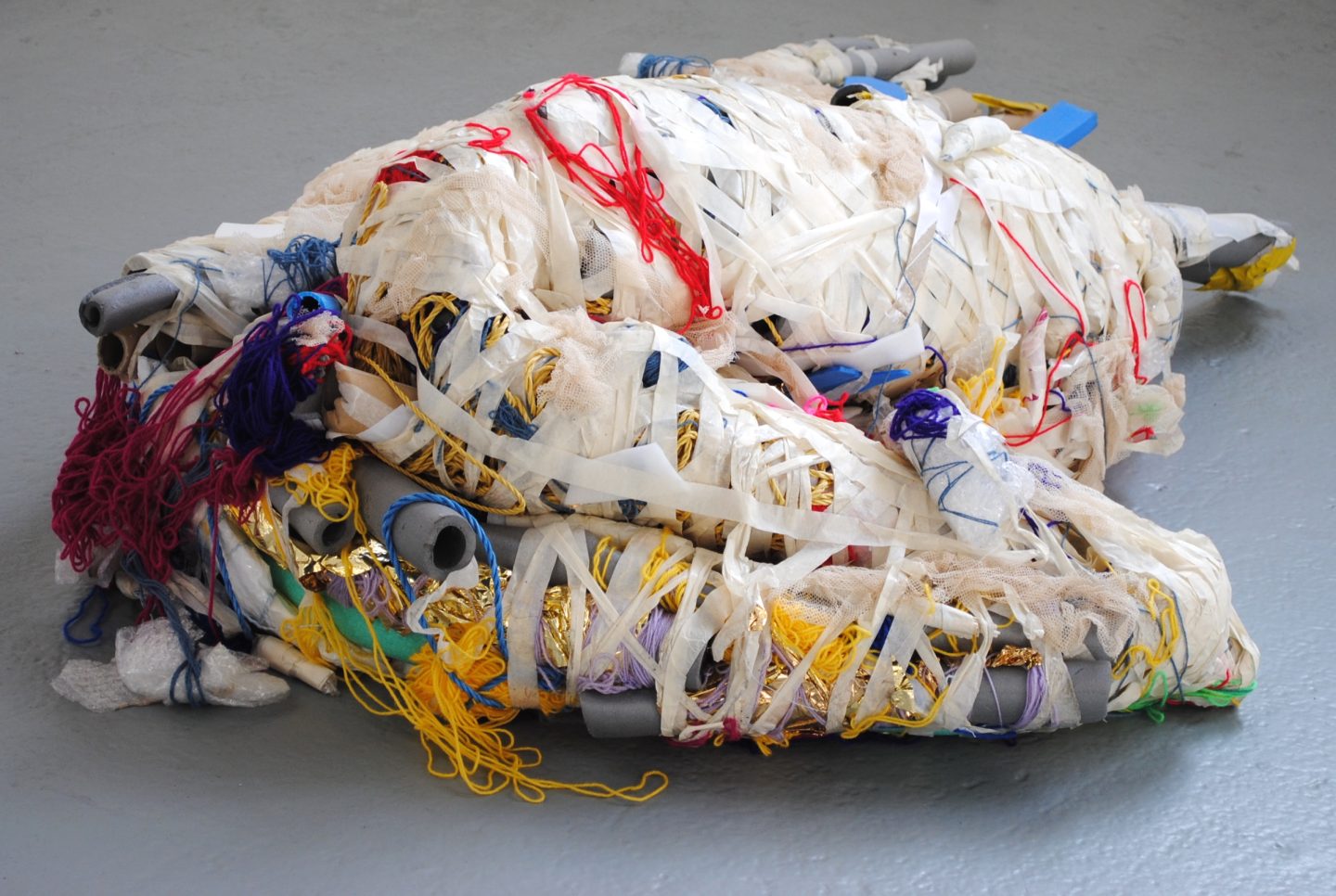 A multimedia sculpture made up of textiles, foam tubes, coloured yarn and bubble wrap bound together with masking tape.
