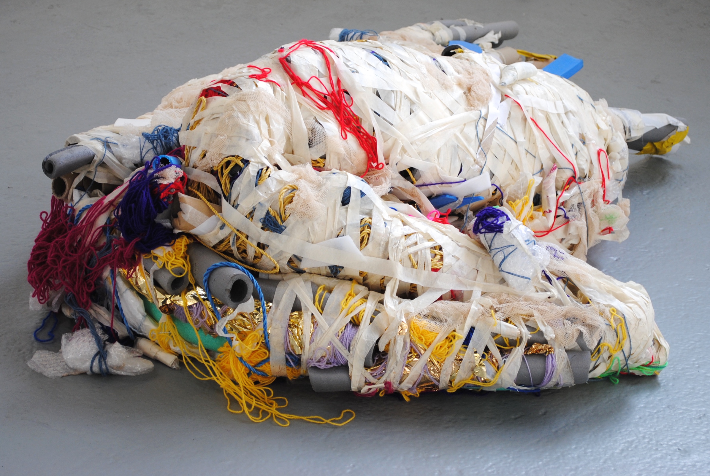 A multimedia sculpture made up of textiles, foam tubes, coloured yarn and bubble wrap bound together with masking tape.