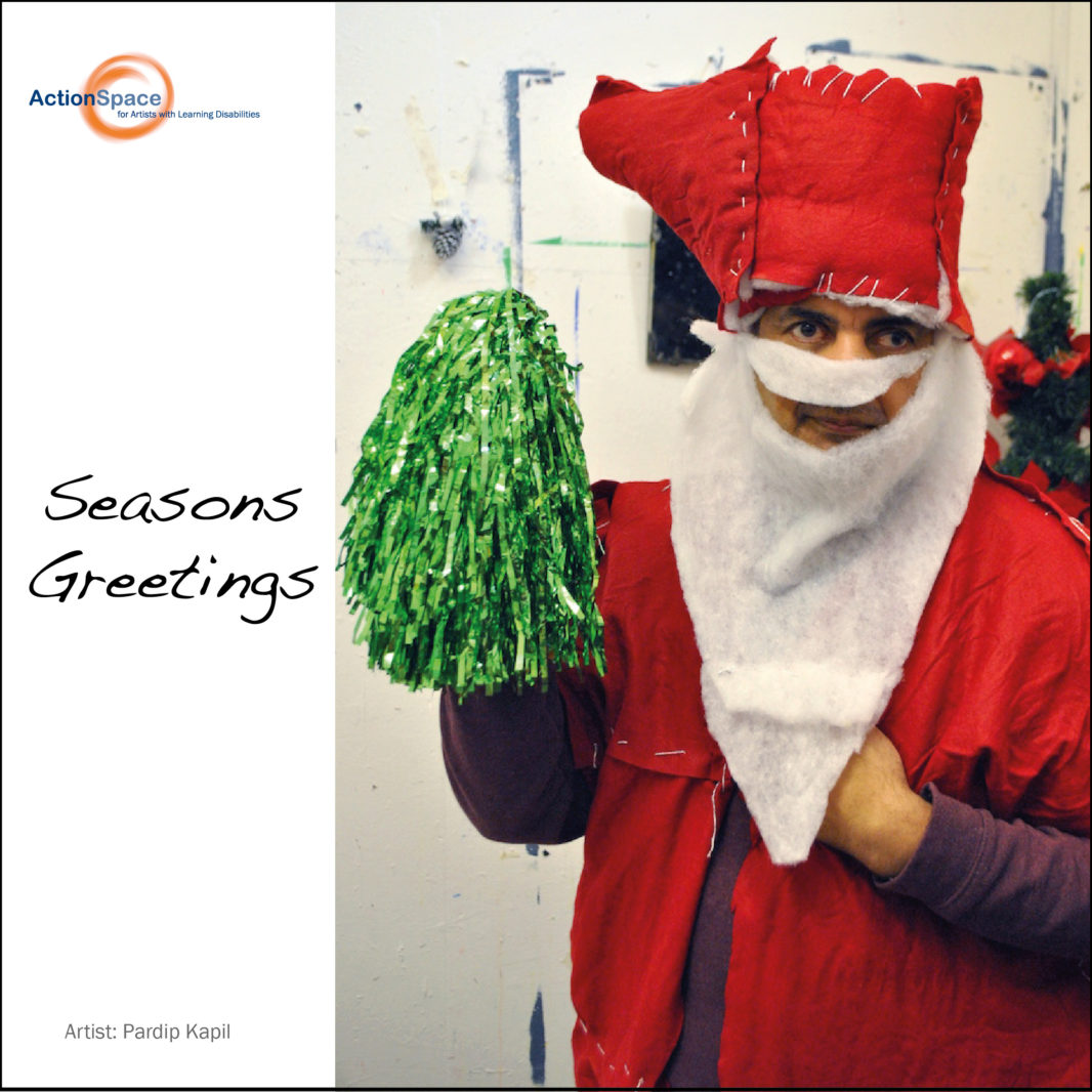 A christmas card, showing Pardip Kapil dressed up as Santa, with the words 'seasons greetings' on the card