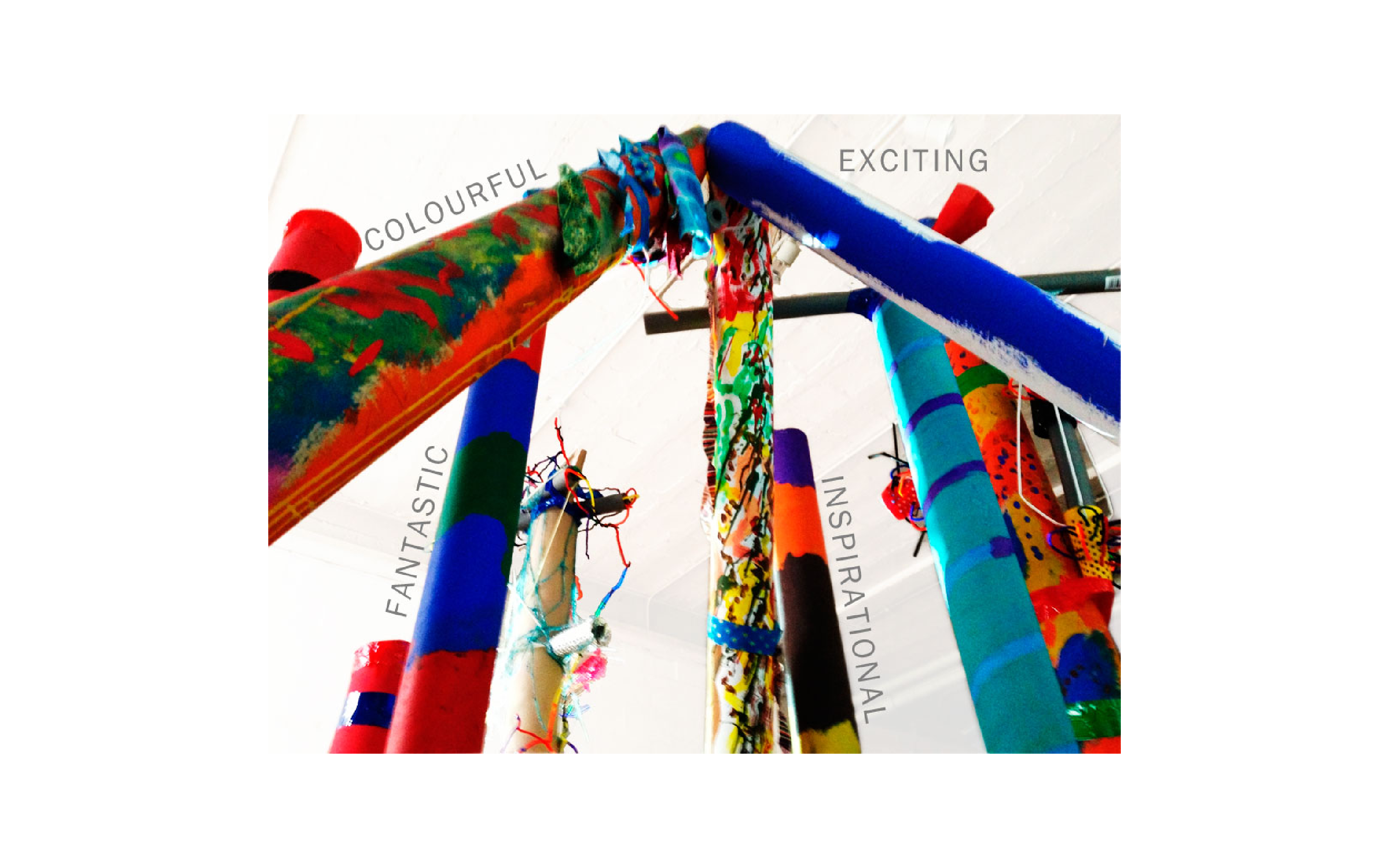 A close up photograph of an installation made of tall painted cardboard tubes with the words "colourful, exciting, fantastic, inspirational".